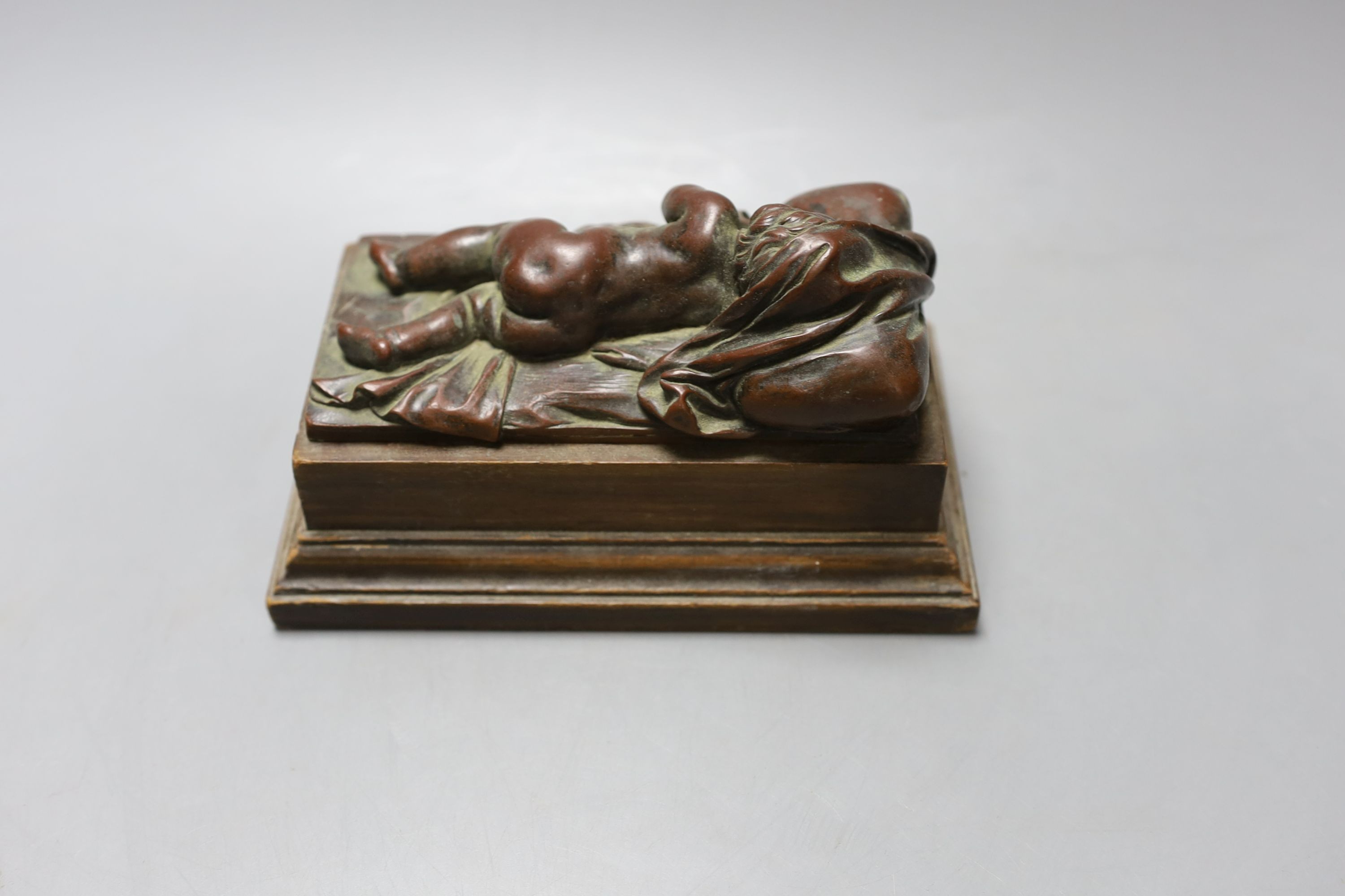 An electrotype figure of a recumbent putti on wooden base